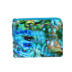 May include: A blue and green zippered pouch with a swirling, iridescent pattern. The pouch is made of fabric and has a zipper closure.