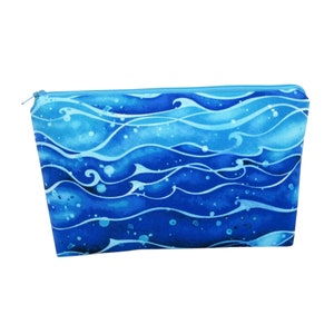 May include: A blue and light blue zippered pouch with a watercolor wave pattern.