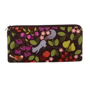 May include: A brown zippered pouch with a colorful floral pattern featuring birds, squirrels, and fruit. The pattern includes shades of pink, purple, green, red, and blue.