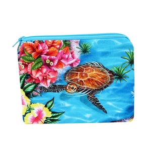 May include: A blue zippered pouch with a colorful floral and sea turtle design. The turtle is swimming in blue water with pink and yellow flowers.