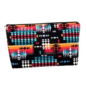 May include: A black zippered pouch with a colorful geometric pattern featuring turquoise, orange, red, white, and gray triangles.