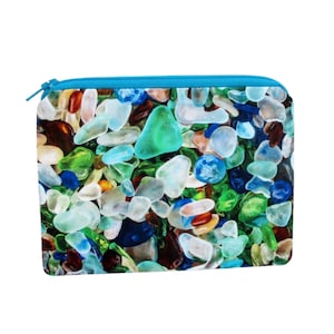 May include: A blue zippered pouch with a colorful sea glass pattern. The pouch is made of fabric and has a zipper closure.