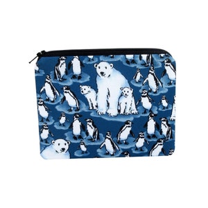 May include: A blue zippered pouch with a white polar bear and penguin pattern. The pouch is made of fabric and has a black zipper.