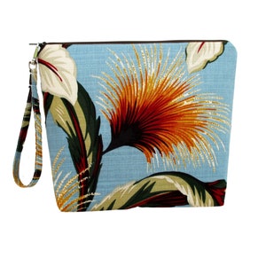 May include: A blue fabric pouch with a zipper closure and a brown strap. The pouch features a colorful floral print with orange, red, yellow, green, and white flowers.
