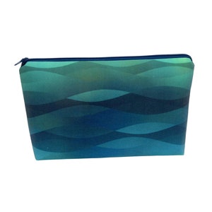 May include: A blue and green zippered pouch with a wavy pattern.