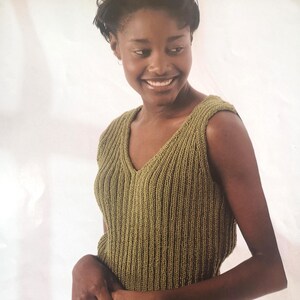 May include: Olive green knitted sleeveless top with a V-neck. The top has a ribbed texture and a simple, classic design. The garment is made of a soft, comfortable material.
