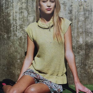 May include: A woman wearing a light green knit top and a floral print skirt sits on a green surface. A vintage tennis racket rests nearby. The text "Summer Ties" is visible in the upper right corner.