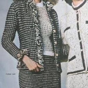 May include: Two women wearing vintage black and white checkered skirt suits. One suit has a matching jacket with a ruffled trim and gold buttons. The other suit is white with black trim and buttons. The outfits are classic and stylish.