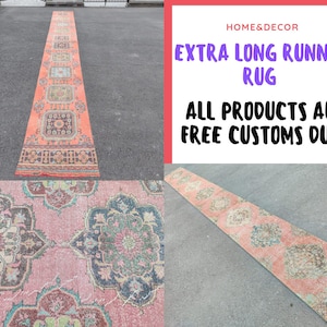 Puede incluir: Una alfombra de corredor extra larga con un aspecto vintage desgastado. La alfombra presenta un patrón repetitivo de diseños florales y geométricos en tonos coral, azul y crema. La alfombra se muestra sobre una superficie gris.
