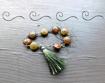 Fever Dream.  Swirl Picasso Glass & Silk Tassel Bracelet. Olive green and honey Translucent glass beaded bracelet  #FestiveEtsyFinds