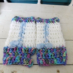 May include: A pair of white crocheted fingerless gloves with blue ribbon accents and a colourful crocheted cuff.