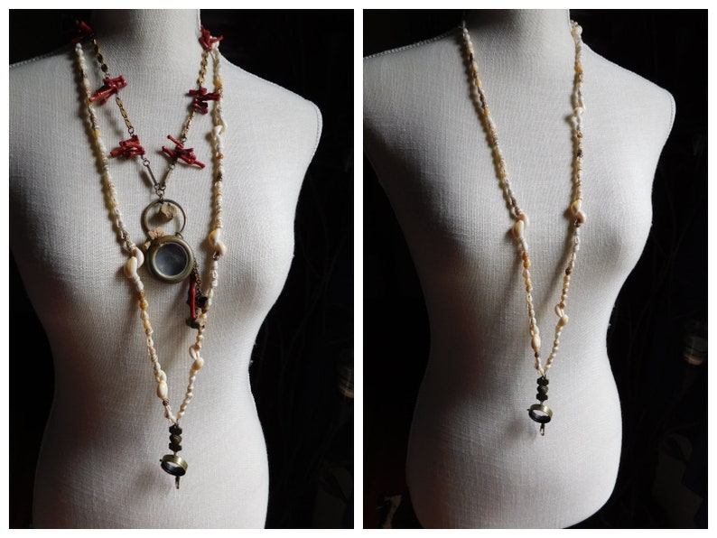 May include: Two necklaces on a white mannequin. The necklace on the left is made of red coral, gold chain, and white shell beads. The necklace on the right is made of white shell beads and has a small, round, silver pendant.