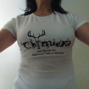 May include: White t-shirt with a black graphic of a skull with antlers and the word "Chimiera" printed on it. The text "www.Chimiera.com" and "Baba's Jewelry, Oddities & Adornments" are also printed on the shirt.
