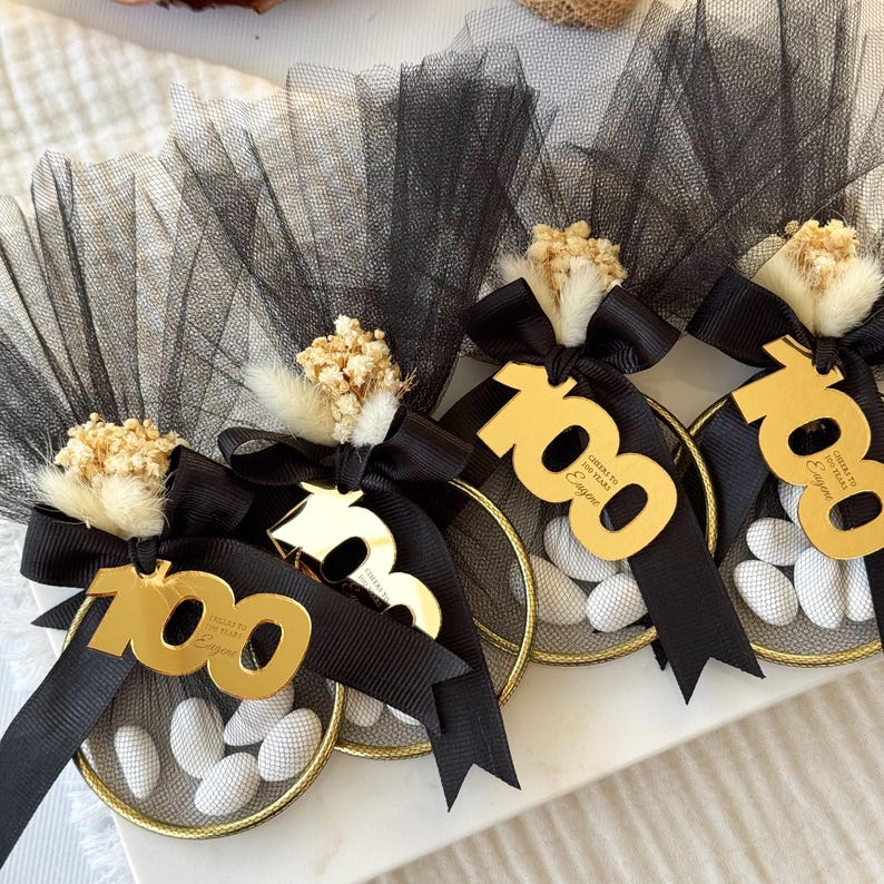 Luxury birthday bomboniere with number tag, gold or pink tulle wrapping, satin bow, and white almond candies — handmade favor gift for party guests.
