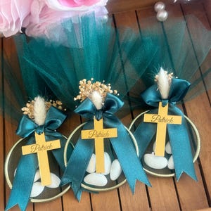 Handmade personalized almond candy bomboniere favor with tulle wrapping, satin ribbon bow, and dried flower decoration. Includes sugared almonds inside a round mesh base — perfect for baptism, christening, communion, or baby shower favors