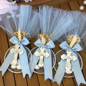 Handmade personalized almond candy bomboniere favor with tulle wrapping, satin ribbon bow, and dried flower decoration. Includes sugared almonds inside a round mesh base — perfect for baptism, christening, communion, or baby shower favors