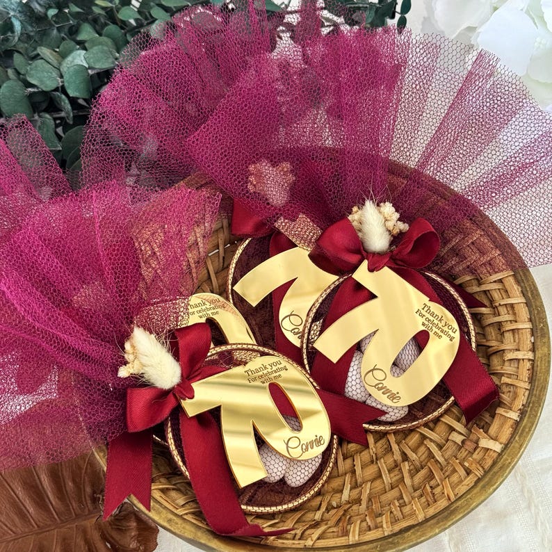 Handmade almond candy favor with gold number tag, dried floral detail, and soft tulle — unique Italian bomboniere for 60th birthday celebration