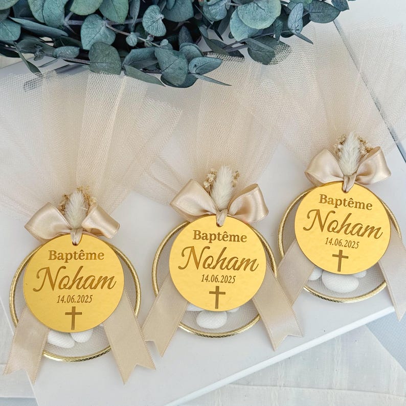 Handmade personalized almond candy bomboniere favor with tulle wrapping, satin ribbon bow, and dried flower decoration. Includes sugared almonds inside a round mesh base — perfect for baptism, christening, communion, or baby shower favors
