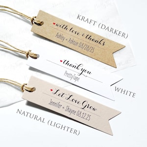 May include: Three different styles of wedding favor tags with twine. The tags are brown, white, and natural. The text on the tags reads "with love & thanks", "thank you", and "Let Love Grow".