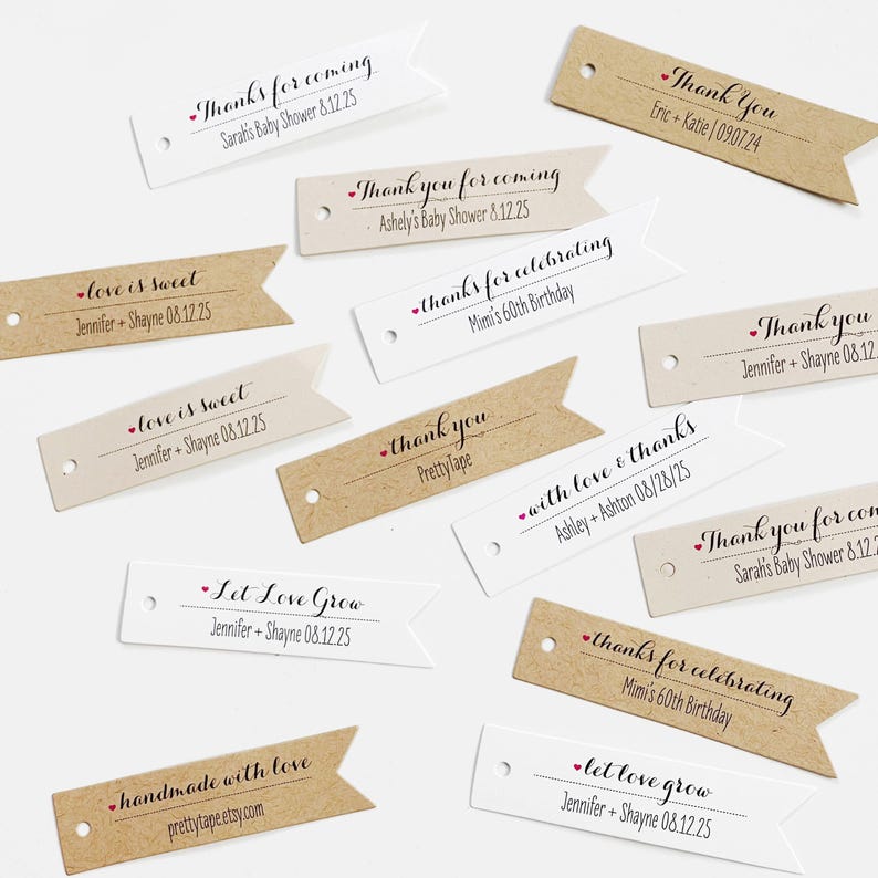May include: A collection of white and brown paper gift tags with various messages, including "love is sweet", "let love grow", "thanks for celebrating", and "with love & thanks".