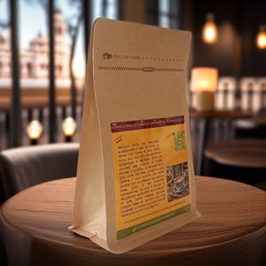 Könnte beinhalten: Ein brauner Papierbeutel mit einem Etikett, auf dem "La Vraie Alternative Durable au Cafe Basee de Noix de Cajou" und "Entdecken Sie eine einzigartige Alternative, die in Geschmack und Qualität außergewöhnlich ist, 100% natürlich, aus Cashewnüssen hergestellt, für ein achtsames und authentisches Kaffeeerlebnis. Reich an Kohlenhydraten, Proteinen und Aminosäuren, trägt sie zu Ihrem Wohlbefinden bei. Genießen Sie einen einzigartigen Kaffee mit einem lebendigen Aroma, einem reichen Geschmack und einer cremigen Textur. Es ist ein nachhaltiges Produkt, das den Kampf gegen Lebensmittelverschwendung fördert. Wählen Sie ein Produkt, das Ihre Erfahrung bei jedem Schluck bereichert!"
