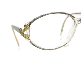 May include: Clear plastic oval-shaped eyeglasses with gold accents on the temples.