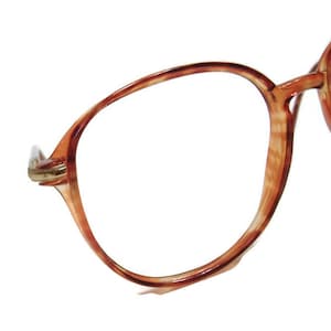 May include: A pair of brown tortoiseshell spectacles with a rounded frame.