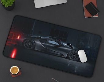 Peut inclure: Un tapis de bureau rectangulaire représentant une voiture de sport gris foncé garée dans un garage sombre. La voiture est vue de profil avec des roues noires et une lueur de feu arrière rouge. Une souris d'ordinateur blanche est posée dessus.