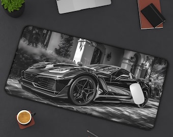 Peut inclure: Un tapis de bureau rectangulaire présentant une impression photographique en noir et blanc d'une voiture de sport garée sur une surface pavée. La voiture est orientée vers la gauche, révélant sa calandre, ses phares et ses jantes à cinq branches.