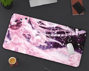 May include: A rectangular desk mat featuring a large-scale anime illustration of a character with long pink hair and blue eyes, wearing a ruffled pink dress and holding a fan, set against a dark background with falling pink flower petals.