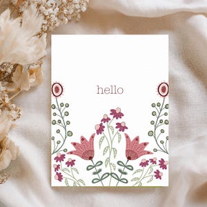 Könnte beinhalten: Weiße Grußkarte mit dem Wort "hello" in einer weichen braunen Schriftart. Die Karte zeigt ein Blumendesign mit rosa und bordeauxfarbenen Blumen und grünen Blättern. Das Gesamtdesign ist schlicht und elegant.