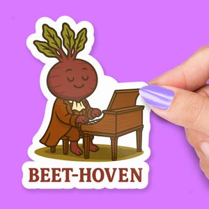 May include: A sticker featuring a cartoon beet character dressed in a brown coat, playing a brown piano. The sticker has the text "BEET-HOVEN" in brown letters. The beet has a smiling face and green leafy top.