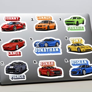Puede incluir: Una colección de nueve pegatinas de coches en un portátil. Cada pegatina presenta un diseño de coche diferente en varios colores, con un nombre impreso encima o debajo del coche. Los nombres incluyen Johnny, Connor, Frankie, Lance, Jonathan, Tony, Pierce, Jonah y Roman.