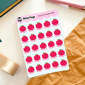 May include: A sheet of kiss-cut stickers featuring a repeating pattern of smiling raspberry illustrations with the text "Berry Good Job." The stickers are pink and green, with the OtterTags logo in the upper left corner.