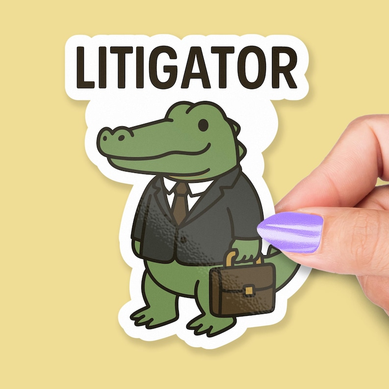 Pode incluir: Um adesivo com um jacar&eacute; de desenho animado em um terno preto, gravata e carregando uma pasta. A palavra "LITIGATOR" &eacute; impressa acima do jacar&eacute; em letras marrons escuras. O jacar&eacute; &eacute; verde com um fundo branco.