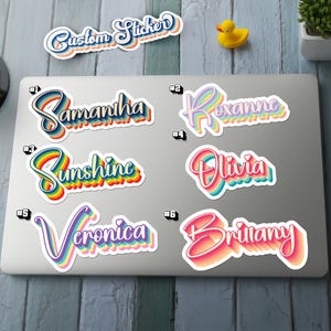 Könnte beinhalten: Eine Sammlung von individuellen Aufklebern mit Namen und dem Text "Custom Sticker". Die Aufkleber haben ein Retro-Regenbogen-Design mit Namen wie Samantha, Roxanne, Sunshine, Olivia, Veronica und Brittany. Die Aufkleber befinden sich auf einem Laptop.