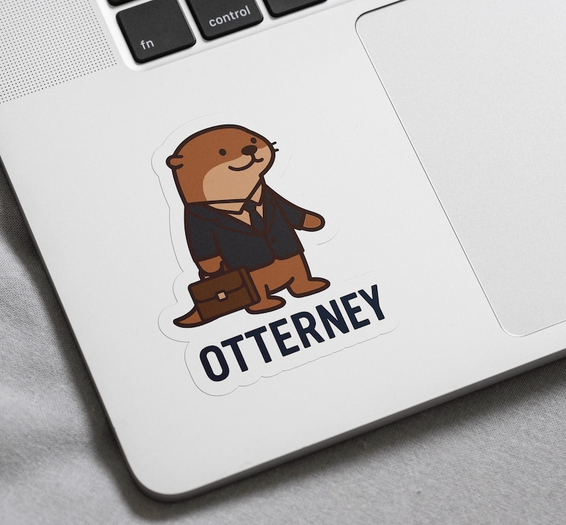 K&ouml;nnte beinhalten: Ein Aufkleber mit einem Cartoon-Otter in einem Anzug, der eine Aktentasche h&auml;lt. Der Otter ist braun und hellbraun und tr&auml;gt einen schwarzen Anzug und eine Krawatte. Das Wort "OTTERNEY" ist darunter in Marineblau gedruckt.