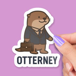 May include: A sticker featuring a cartoon otter in a dark blue suit, tie, and carrying a brown briefcase. The text "OTTERNEY" is printed in white block letters below the otter. The background is a solid light purple.