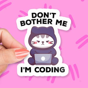 May include: A white sticker with a cartoon cat wearing a purple hoodie and using a laptop. The text on the sticker reads "Don't Bother Me I'm Coding."