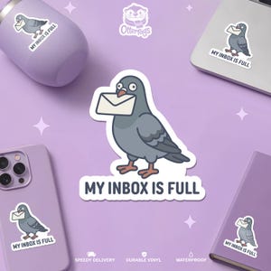 Può includere: Un adesivo in vinile fustellato raffigurante un piccione dei cartoni animati che tiene una busta bianca nel becco. Sotto l'uccello, il testo "MY INBOX IS FULL" è scritto in lettere maiuscole blu scuro. Il design usa toni di grigio, bianco e blu.