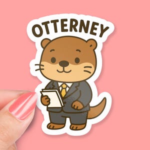 May include: A sticker featuring a cartoon otter dressed in a gray suit and yellow tie, holding a notepad. The word "OTTERNEY" is printed above the otter in brown letters. The background is a solid pink color.