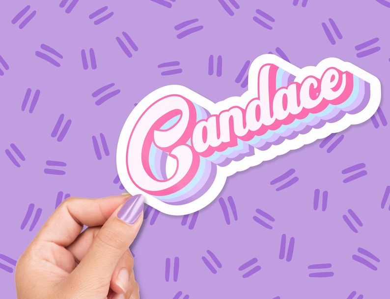 May include: A sticker with the name "Candace" in a retro font, featuring pink, white, and blue layered text with a white outline. The sticker is held against a purple background with a repeating pattern of short, parallel lines.