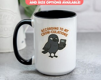 May include: White ceramic mug with a black interior and handle. The mug features a cartoon crow holding a calculator, with the text "ACCORDING TO MY CROW-CULATIONS". The top banner reads "MORE COLORS AND SIZE OPTIONS AVAILABLE!"