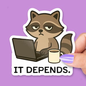 Pode incluir: Um adesivo com um guaxinim de desenho animado com um laptop e uma caneca de café. O guaxinim tem uma expressão mal-humorada. O texto "IT DEPENDS." está impresso abaixo.
