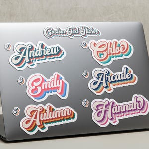May include: A collection of custom text stickers in a retro style, featuring names like "Andrew," "Chloe," and "Hannah." Each sticker has a unique color scheme with a white outline, applied to a laptop.