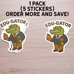 May include: A stack of stickers featuring a cartoon alligator wearing glasses, a blazer, and holding an apple and a book. The stickers have the text "EDU-GATOR" on them. The text "1 PACK (5 STICKERS) ORDER MORE AND SAVE!" is also visible.