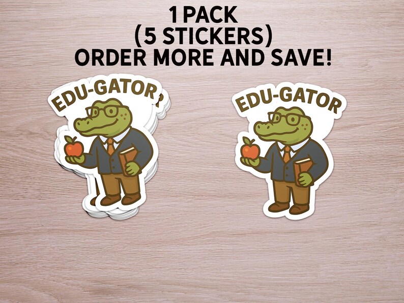 May include: A stack of stickers featuring a cartoon alligator wearing glasses, a blazer, and holding an apple and a book. The stickers have the text "EDU-GATOR" on them. The text "1 PACK (5 STICKERS) ORDER MORE AND SAVE!" is also visible.