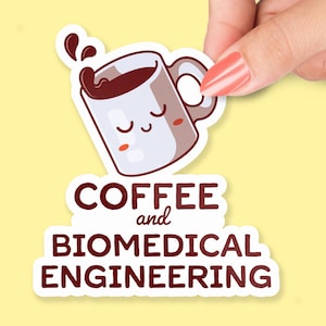 Op de afbeelding: Een witte sticker met een cartoon koffiekopje met een bruine vloeistof en een vrolijk gezicht. De tekst "COFFEE and BIOMEDICAL ENGINEERING" staat in bruine letters.