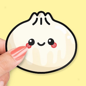 May include: A white cartoon dumpling with a happy face and red cheeks. The dumpling has a black outline and is drawn in a simple, cartoon style.