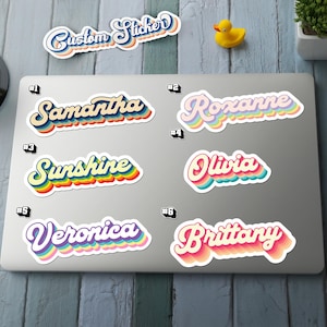 May include: A collection of custom stickers with names and the text "Custom Sticker". The stickers feature a retro design with colorful, layered text. Names include Samantha, Roxanne, Sunshine, Olivia, Veronica, and Brittany.